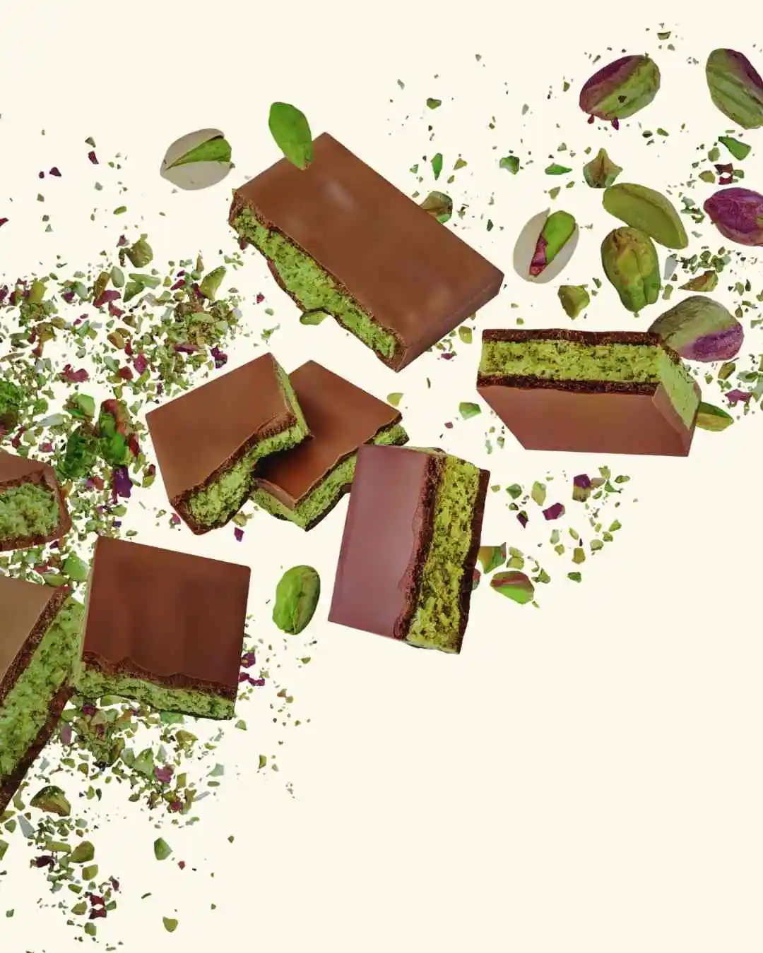 Dubai chocolate bar pieces exploding with pistachio knafeh filling – milk chocolate and green pistachio kataifi layers flying in air