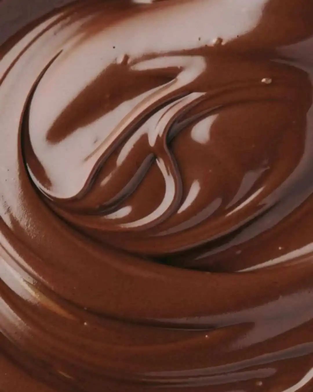 Melted Dubai chocolate swirl close up – smooth dark and milk chocolate being mixed together
